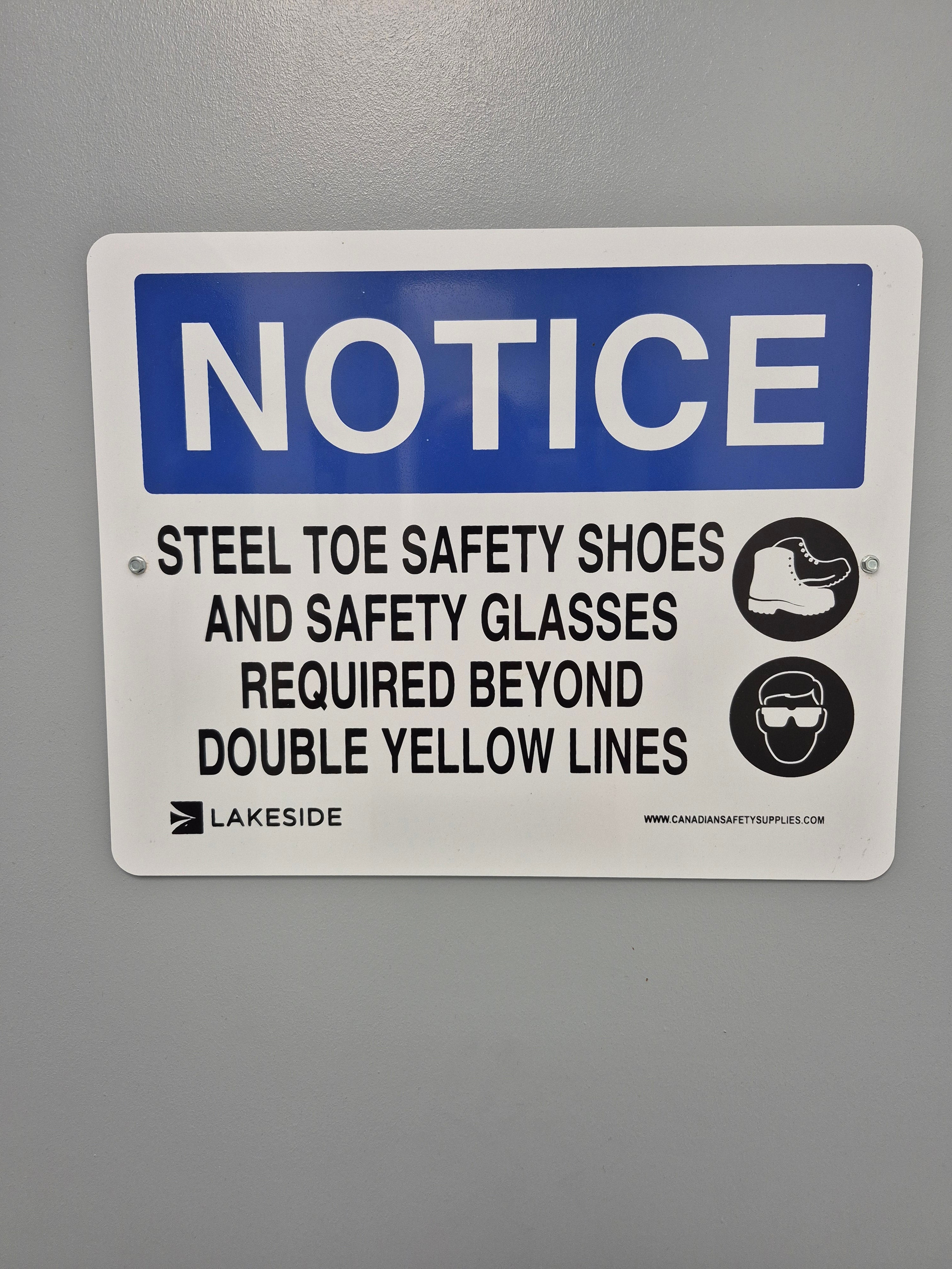 STEEL TOE SAFETY SHOES AND SAFETY GLASSES REQUIRED BEYOND DOUBLE YELLOW LINES - NOTICE SIGN